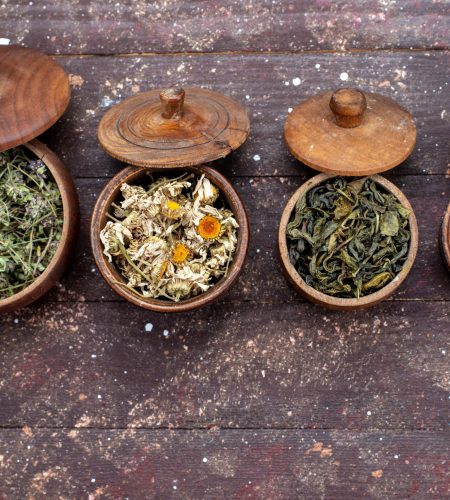 top-view-dried-seasonings-different-colored-inside-bowls-brown-background-green-mint-dry